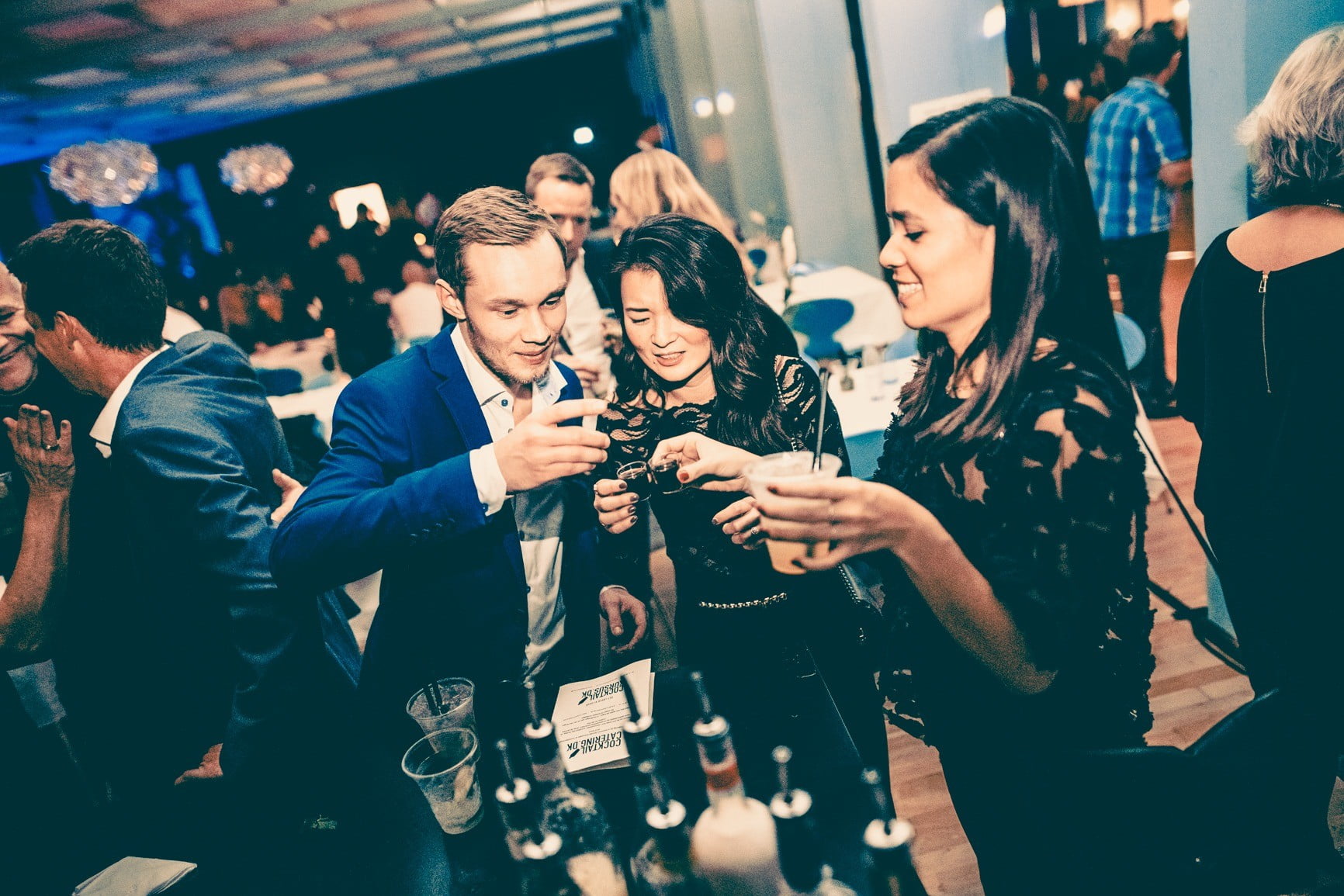 Deltagere på et teambuilding cocktailkursus nyder deres drinks og har det sjovt sammen